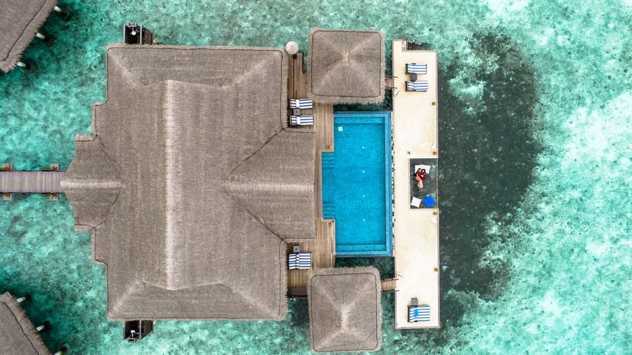 Aerial view of a luxury overwater villa with private pool in the Maldives